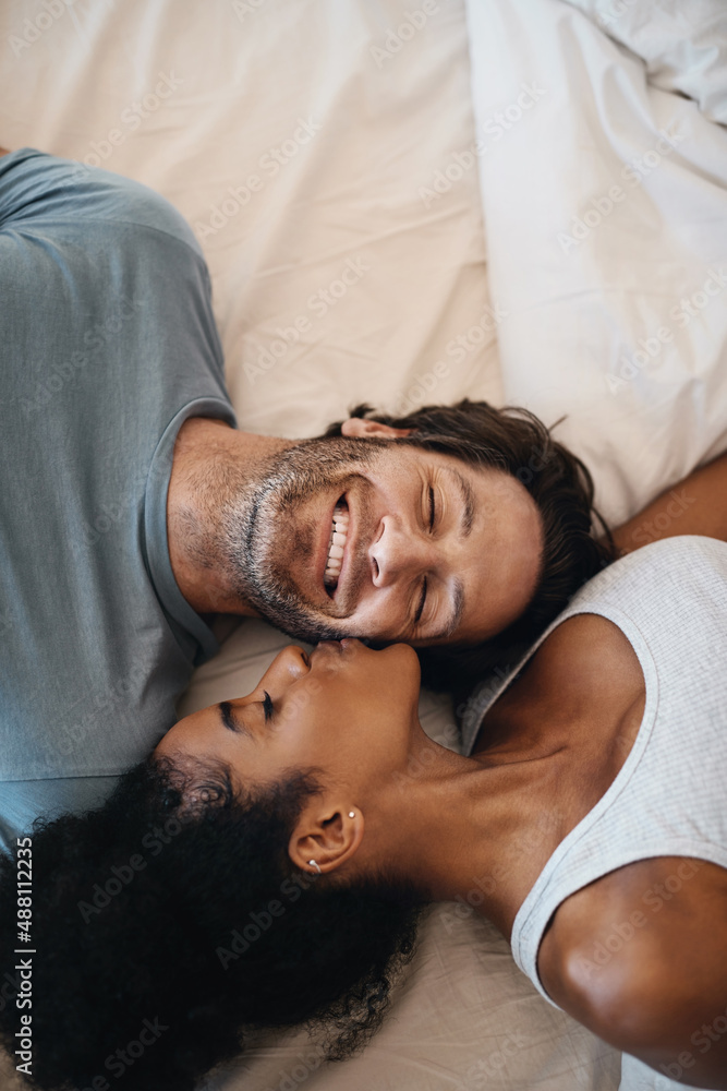 Youre the reason for my happiness. Cropped shot of a happy young couple lying in bed together. - obrazy, fototapety, plakaty 