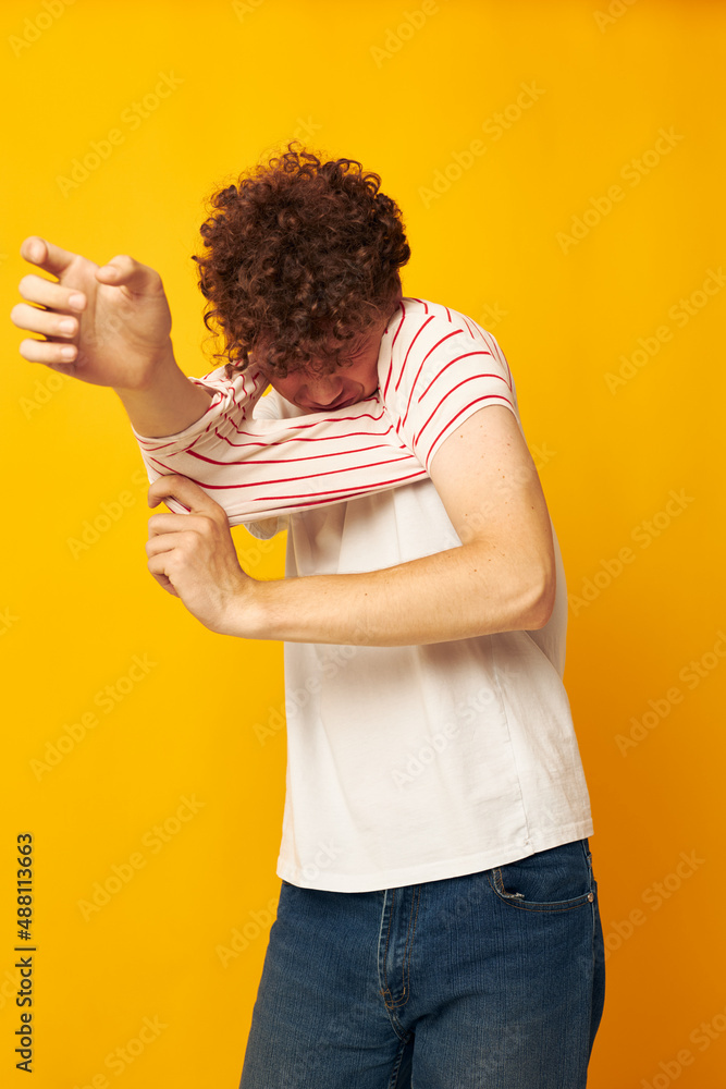 cute red-haired guy putting on a striped t-shirt posing isolated background unaltered cute red-haired guy putting on a striped t-shirt posing isolated background unaltered