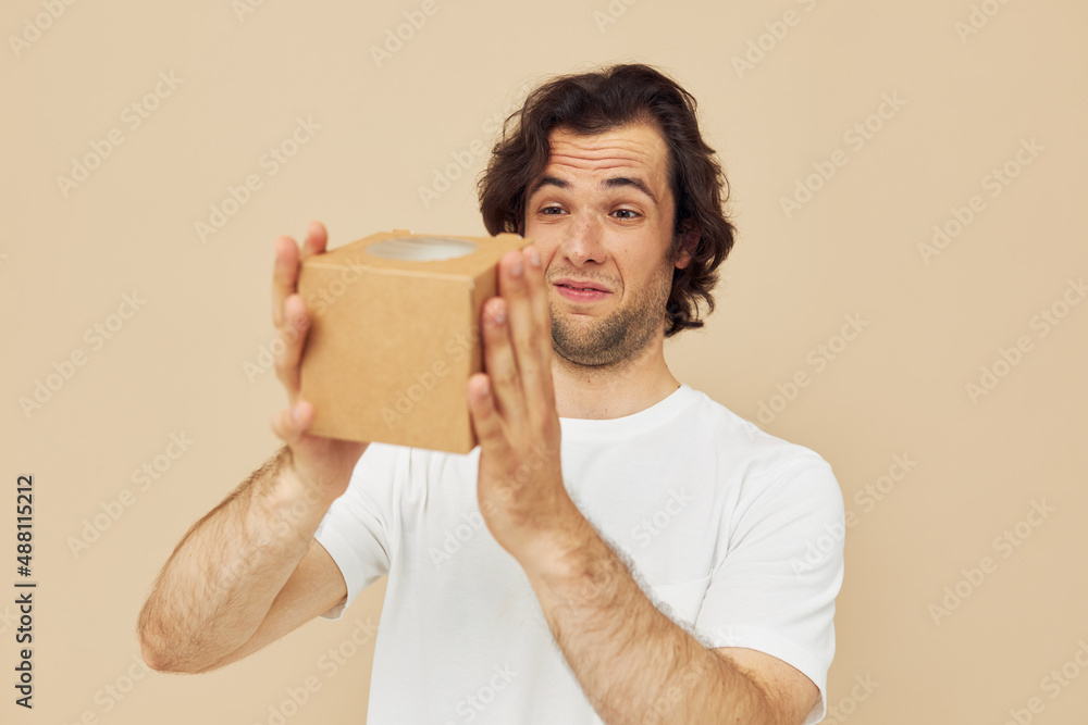 handsome man holding a cardboard small box in his hands handsome man holding a cardboard small box in his hands