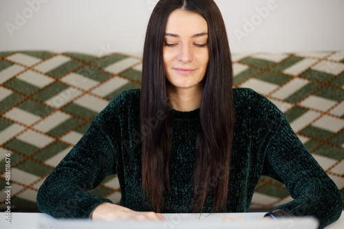 Beautiful white woman working on laptop computer. Adult student person studying online with smile. Young Caucasian female doing distant freelance work on modern notebook pc connected to internet