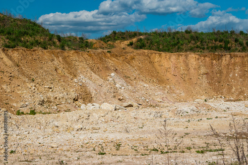 Slope on a limestone quarry, white limestone is covered from above with loamy soil photo