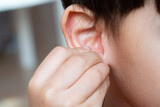 Child squeezing the earlobe, concept of hearing problems