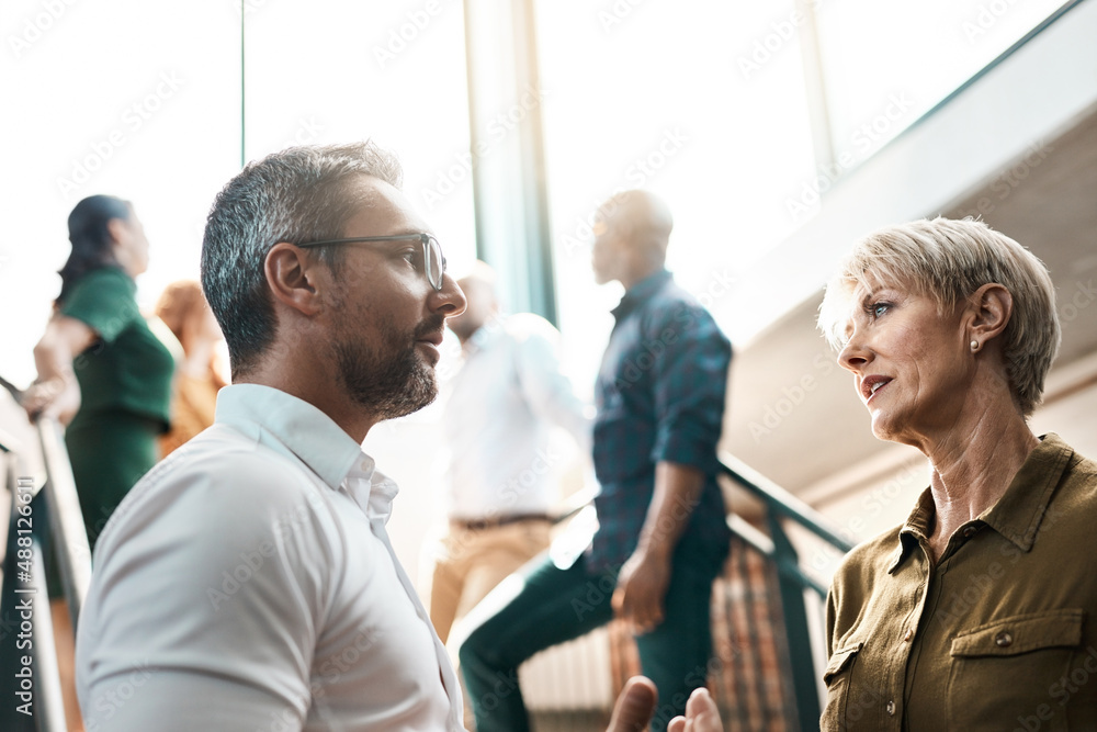 Exchanging some business advice. Shot of two businesspeople talking to each other while standing on a stairwell. Exchanging some business advice. Shot of two businesspeople talking to each other while standing on a stairwell.