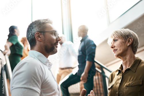 Exchanging some business advice. Shot of two businesspeople talking to each other while standing on a stairwell.