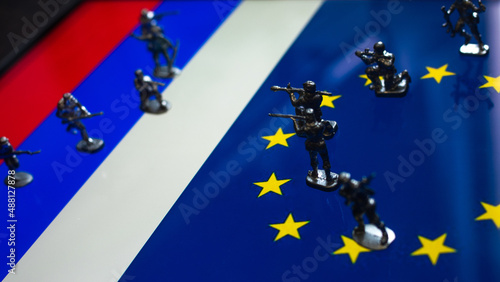 The concept of the economic and political crisis between the European Union and Russia, toy soldiers attacking each other against the background of national flags.