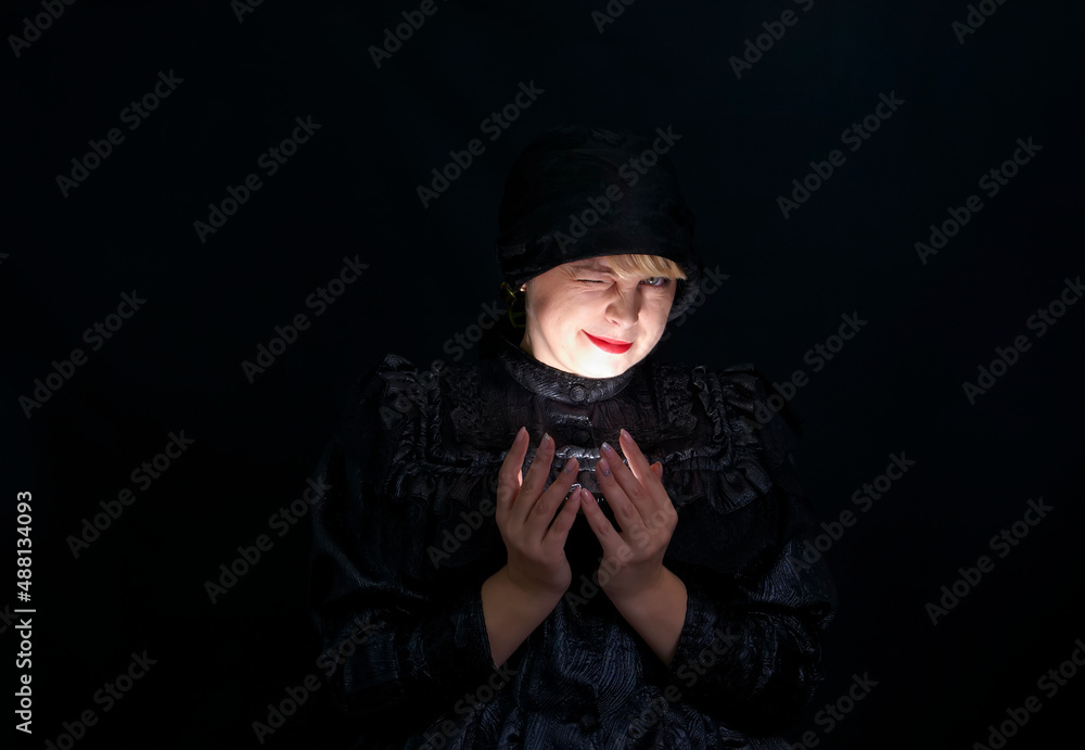 Attractive woman in black clothes holding a light source in her hands Attractive woman in black clothes holding a light source in her hands