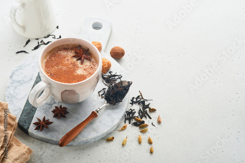Masala tea. Masala chai spiced tea with milk and spices on light grey background. Traditional indian drink. Spice drink. Copy space. Selective focus.