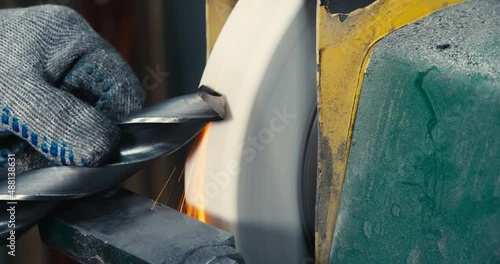 sharpen drill bits on a bench grinder, close up.