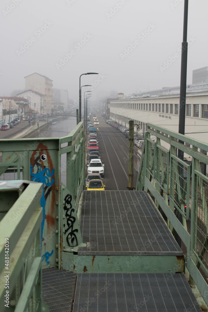 Milan, Don Lorenzo Milani overpass,
evocative image of the iron bridge along the Naviglio used
to connect a ceramic factory with the railway under a gray sky