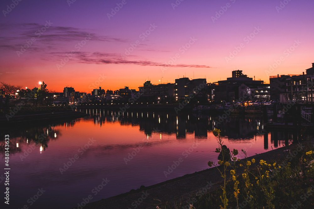 日没後の街のシルエットと運河に反射する街