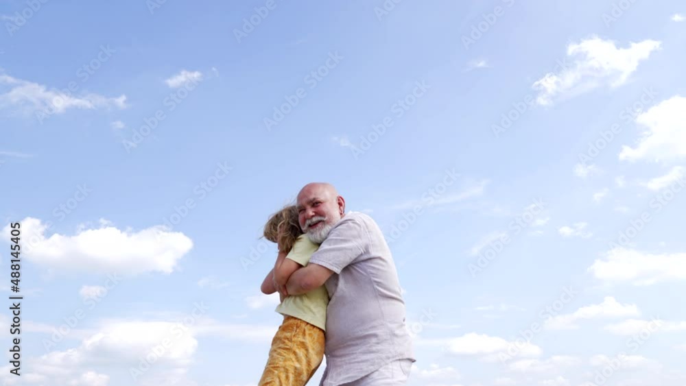 Happy grandfather smile hugging grandson child sky-high, happiness