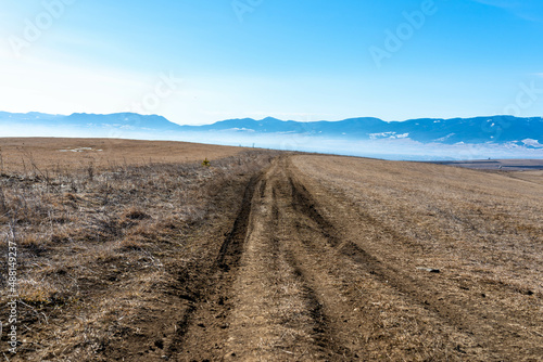 Dirt road leading on the top of the hill at late winter in the Carpathian mountains.