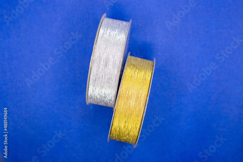 Fototapeta Naklejka Na Ścianę i Meble -  Two packing tapes in gold and silver blue background.
