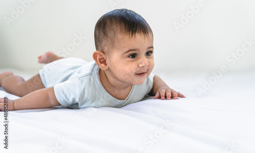 Portrait of happy little baby lying on bed