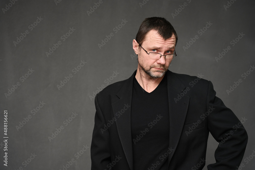Portrait of an adult man in glasses with disbelief on a gray background Portrait of an adult man in glasses with disbelief on a gray background