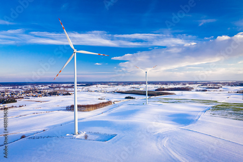 Alternative energy at winter. Snowy field and wind turbine.