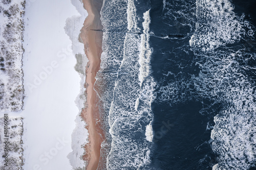 Top down view of winter Baltic sea and snowy beach.