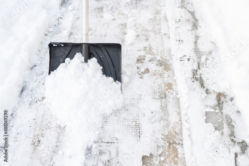 Snow cleaning with a large shovel in winter