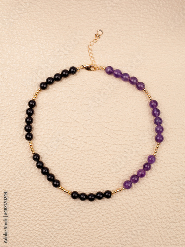 Women`s necklace of black and purple gem stones photo