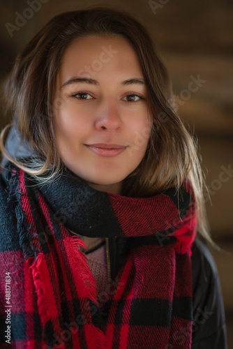 Portrait of a young beautiful brown-haired woman with a red scarf in the forest. © shymar27