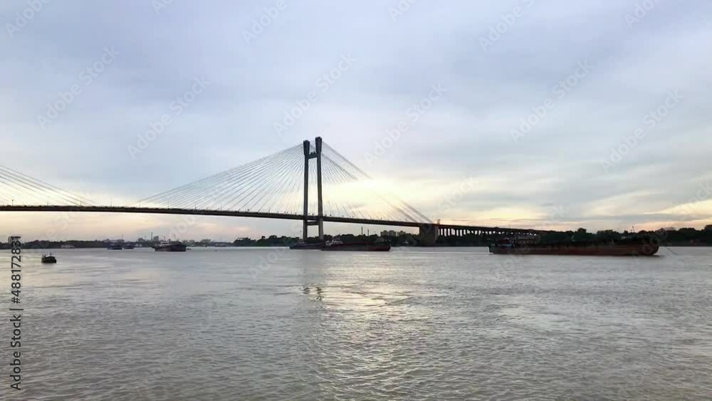 Time lapse of sunset with the Hooghly Bridge in busy Calcutta, India.4K Timelapse of beautiful clouds over Kolkata city with a view of Vidyasagar Setu or Second Hooghly Bridge on the Ganges river. Time lapse of sunset with the Hooghly Bridge in busy Calcutta, India.4K Timelapse of beautiful clouds over Kolkata city with a view of Vidyasagar Setu or Second Hooghly Bridge on the Ganges river.