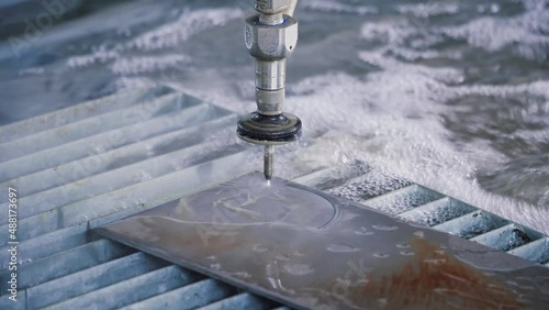 Waterjet metal cutting. Hydroabrasive high pressure CNC machine is working with metal sheet photo