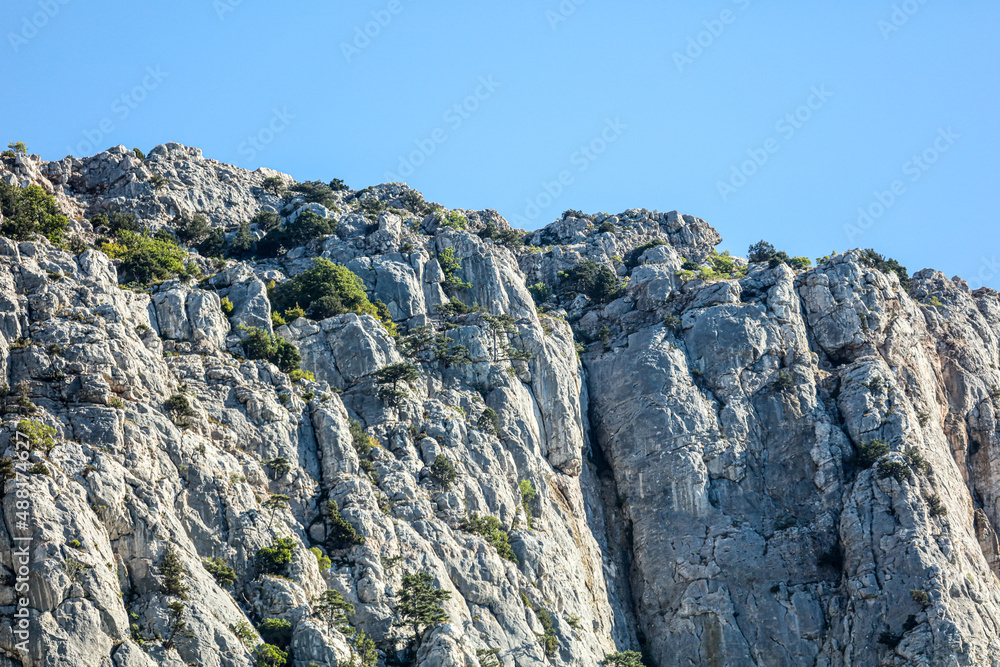 Peaks of rocky mountains against a blue sky.