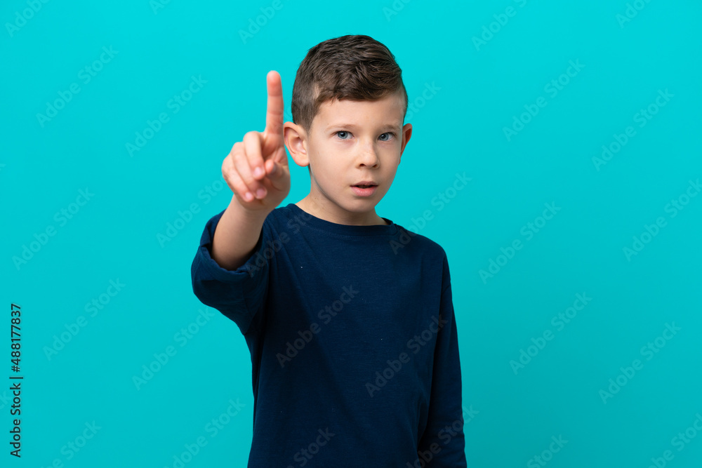 Little kid boy isolated on blue background counting one with serious expression Little kid boy isolated on blue background counting one with serious expression