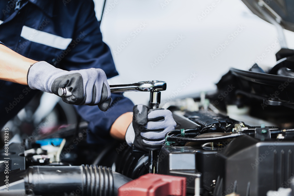 Professional mechanic working on the engine of the car in the garage. Car repair service. Professional mechanic working on the engine of the car in the garage. Car repair service.