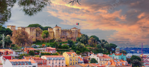 Panorama of the Lisbon city and Castelo de Sao Jorge, known as the Saint George historical castle, at sunset photo