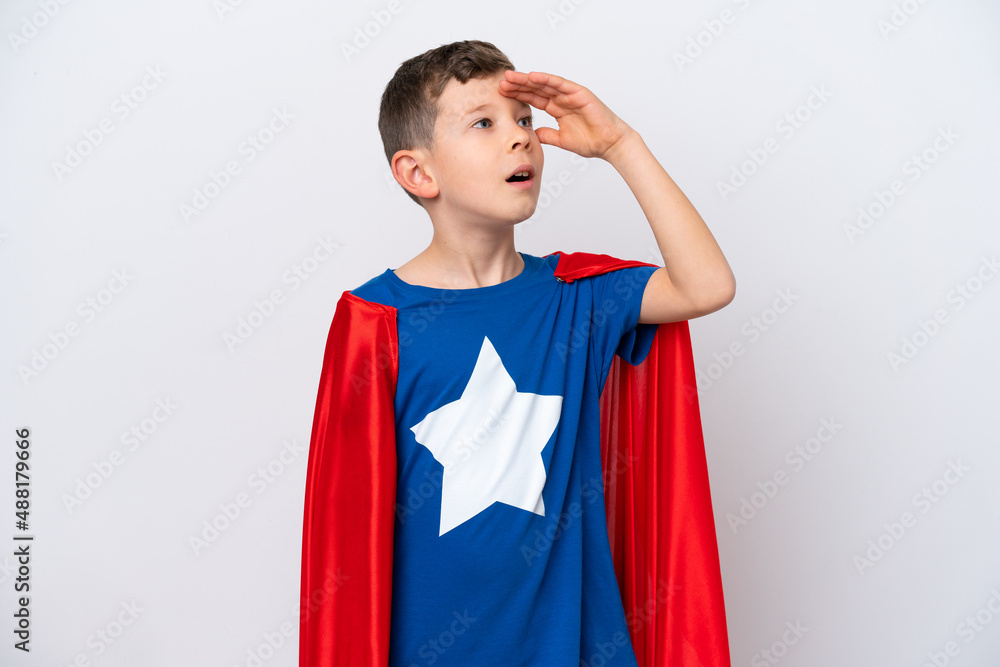Super Hero little boy isolated on white background doing surprise gesture while looking to the side Super Hero little boy isolated on white background doing surprise gesture while looking to the side