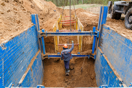 The worker gives a signal to the excavator operator