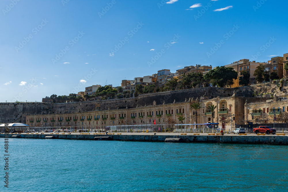 Naklejka premium In front of the Floriana Lines fortifications are the old stores and warehouses at the Valletta Waterfront in Floriana, Malta, next to the Grand Harbour.