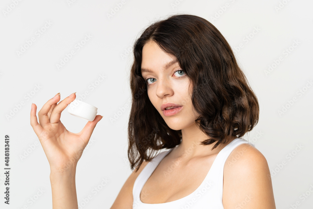 Teenager Ukrainian girl isolated on white background with moisturizer Teenager Ukrainian girl isolated on white background with moisturizer