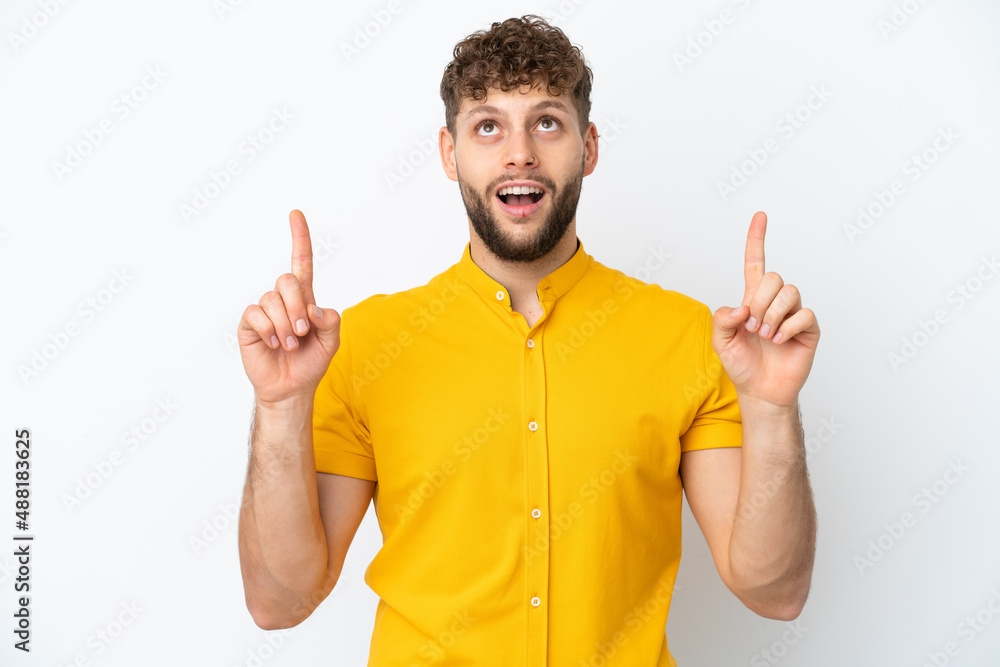 Young handsome caucasian man isolated on white background surprised and pointing up Young handsome caucasian man isolated on white background surprised and pointing up