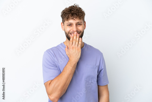 Young handsome caucasian man isolated on white background happy and smiling covering mouth with hand