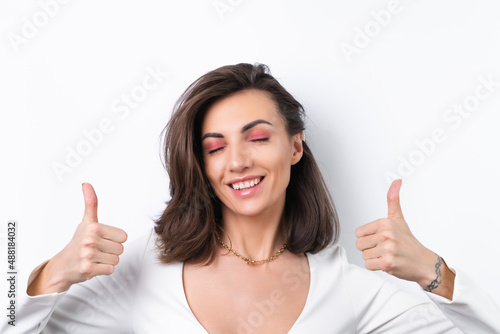 Wallpaper Mural Young woman in a cocktail dress, gold chain and bright spring pink makeup on a white background. Cheerfully smiling showing thumbs up Torontodigital.ca