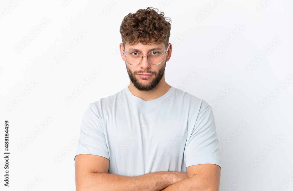 Young handsome caucasian man isolated on white background With glasses and arms crossed