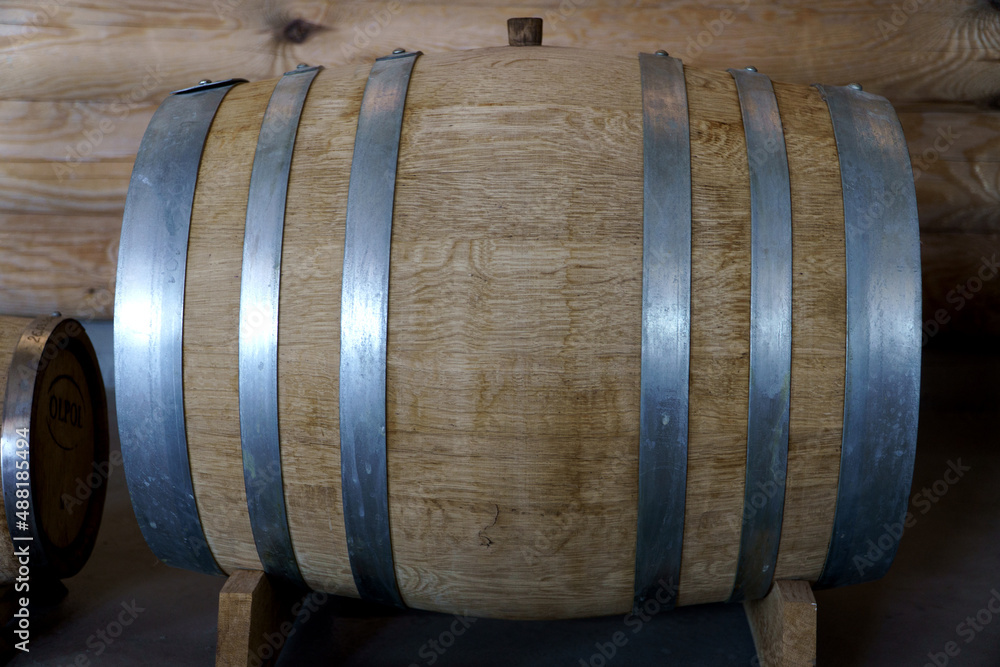A wooden barrel lying on its side in the basement.