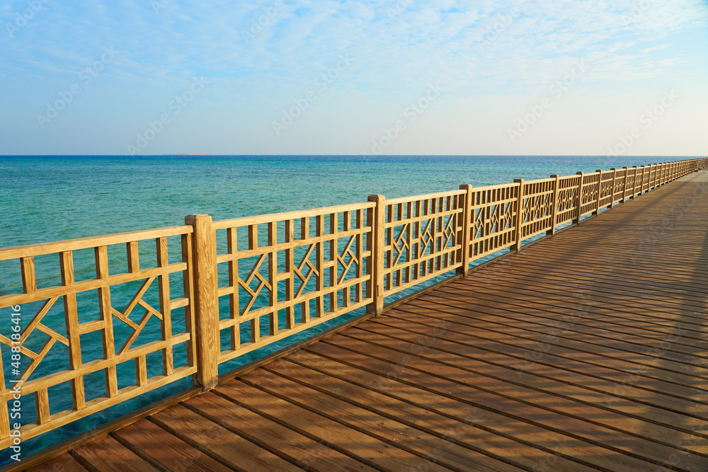 A wooden pier on the shores of the Red Sea with a horizon in the background.