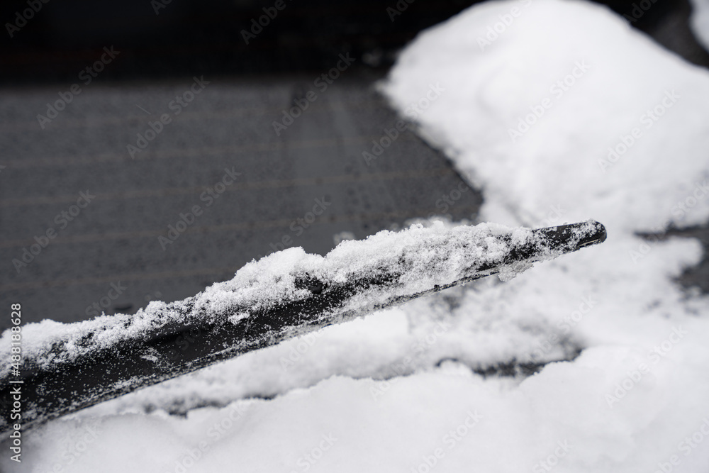 frozen wiper blade is cover in snow and ice after a snow storm