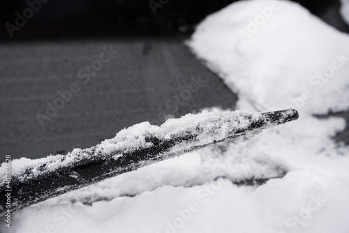 frozen wiper blade is cover in snow and ice after a snow storm