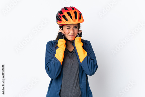 Young cyclist brazilian girl isolated on white  background frustrated and covering ears © luismolinero