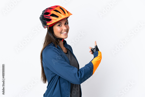 Young cyclist brazilian girl isolated on white background pointing back