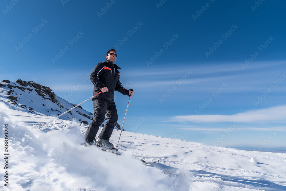 Skier sliding down the mountain on the snow in the ski resort Skier sliding down the mountain on the snow in the ski resort
