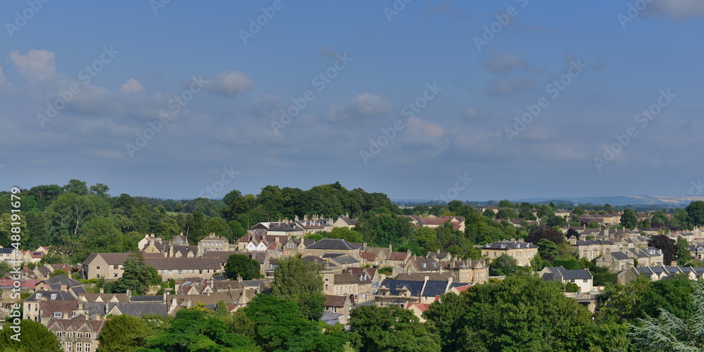 scenic view of a beautiful old town set amongst green leafy trees seen from a high vantage point