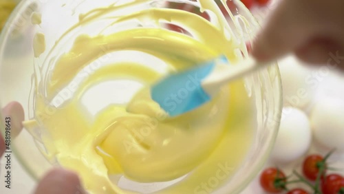 the cook prepares mayonnaise in a bowl. making mayonnaise at home