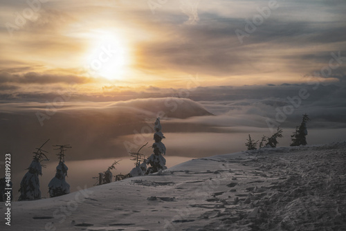 Sunset in Winter with very low clouds and frozen trees dramatic sky mist snow mountain top view © Keramsiemanym