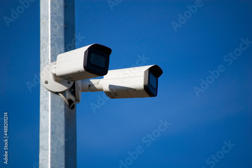 City monitoring system cameras against blue sky.