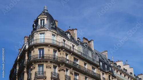 Immobilier ancien à Paris, architecture de la façade d'un immeuble d’angle haussmannien avec balcon (France) photo